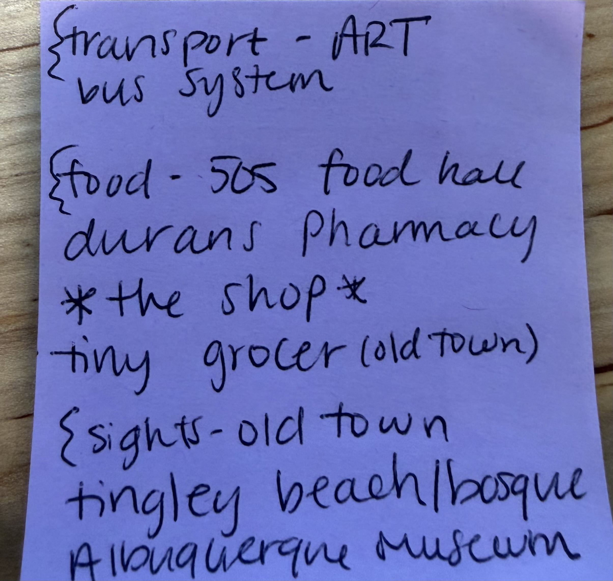 A handwritten purple sticky note listing transport, food and sights recommendations for Albuquerque.